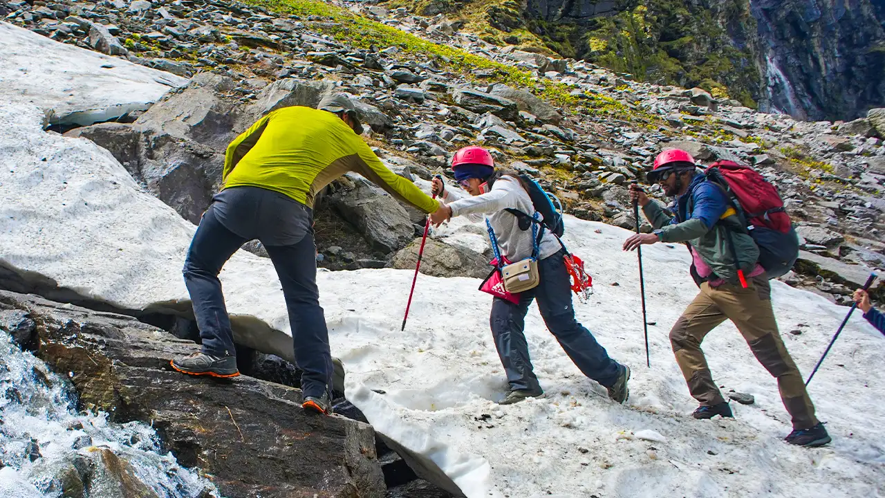 TTH trek leader is helping to a trekker during the snowy trail