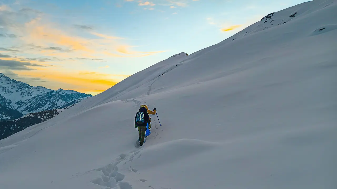 Trekkers ascending toward the summit of Aanacha Top through snow